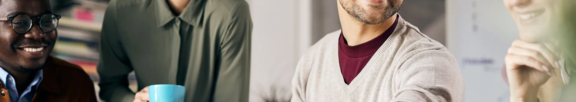 Quatre collègues regardent avec enthousiasme le travail de celui au centre